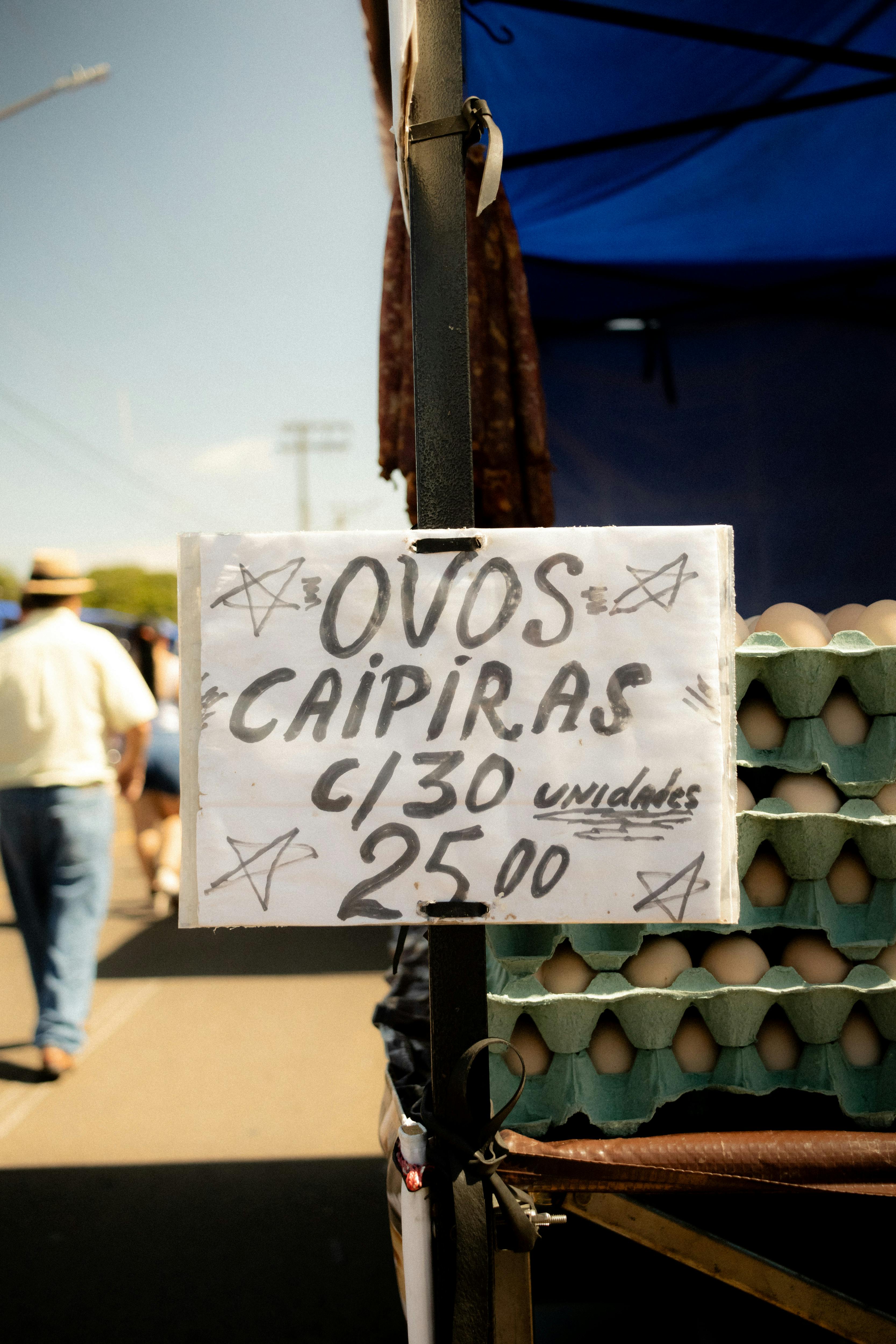 Cartaz de venda de ovos caipiras em feira livre.